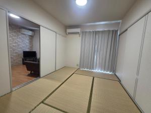 an empty room with a view of a living room at アパートメントホテル憩 in Yanagawa