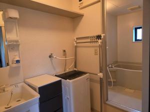 a small bathroom with a sink and a shower at アパートメントホテル憩 in Yanagawa