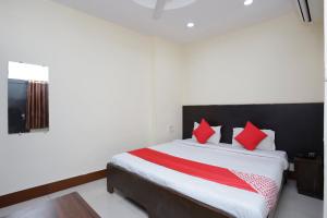 a bedroom with a large bed with red pillows at Hotel O Crown Hidden Residency in Satna +32 photos