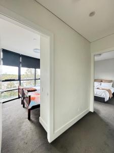 a bedroom with two beds and a large window at Floor-to-Ceiling Park View Oasis at Olympic Park Free Parking Sleeps 5 in Sydney
