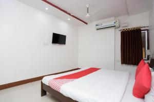 a bedroom with a bed and a tv on the wall at Hotel O Crown Hidden Residency in Satna