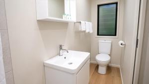 a white bathroom with a toilet and a sink at Chambers Wildlife Rainforest Lodges in Lake Eacham +58 photos
