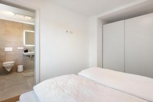 a white bedroom with a bed and a bathroom at Gästehaus Schwert in Salem +136 photos