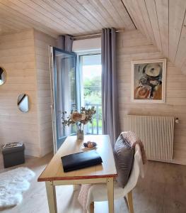 a living room with a table and a window at La Crinière d'Or - Entre mer et campagne in Bonneville-la-Louvet