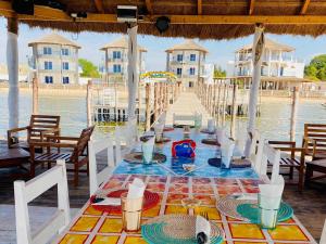 a table on the water with a table set for a meal at Hotel Cap du Sine Saloum in Ndangane +46 photos
