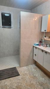 a bathroom with a shower with a counter and a sink at Maison grande terrasse Poligny in Poligny +1 photo