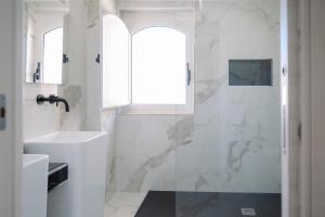 a white bathroom with a sink and a window at The Square - Luxury Apartment in Scilla +31 photos