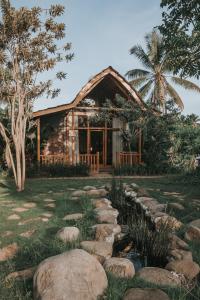 a log cabin with a stone path in front of it at Kusfarm Bali by AHM in Selemadeg +61 photos