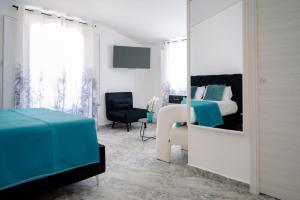 a bedroom with a bed and a chair and a mirror at The Square - Luxury Apartment in Scilla