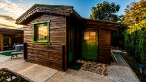 a small wooden cabin with a green door at Hiška Miru Peace Cabin in Mozirje +7 photos