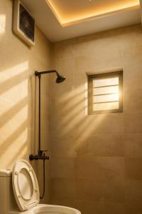 a bathroom with a shower with a toilet and a window at Studio 13 in Islamabad