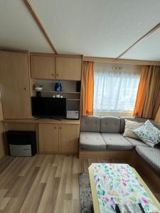 a small living room with a couch and a window at Domki Dolce Vita in Jastarnia