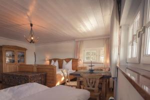 a bedroom with two beds and a table and a bed at Ansitz Wartenfels in Thalgau