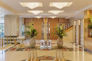 a lobby with two vases with plants on a table at Divani Apollon Palace & Thalasso in Athens