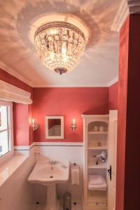 a bathroom with a sink and a chandelier at Ansitz Wartenfels in Thalgau