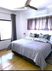 a bedroom with a large bed with purple curtains at Bushbuck Rest in Marloth Park