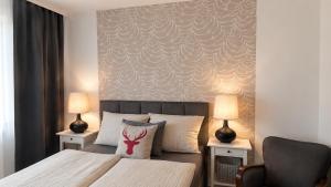 a bedroom with a bed and two lamps and a chair at Willa Apart 19A in Karpacz