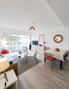 a living room with a couch and a table at L'Océanic in Saint-Georges-de-Didonne