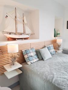 a bedroom with a bed with a boat on the wall at L'Océanic in Saint-Georges-de-Didonne