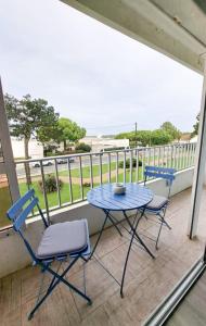 a table and chairs on a balcony with a view of the ocean at L'Océanic in Saint-Georges-de-Didonne
