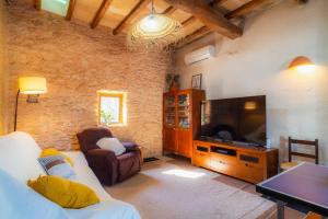 a living room with a couch and a flat screen tv at Can Vicent Corda in Sant Francesc Xavier