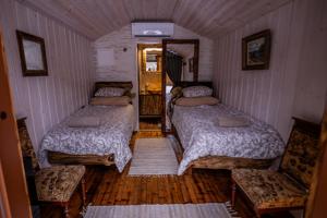 a small room with two beds and two chairs at Metsatiigi Resort in Kersalu +14 photos