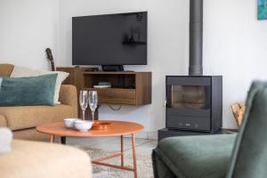 a living room with a fireplace and a tv at Sea Side Village 91 in De Haan