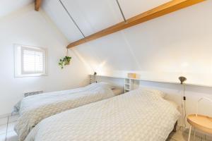 a bedroom with two beds and a table at Sea Side Village 91 in De Haan