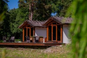 a small house with a porch and chairs on it at Metsatiigi Resort in Kersalu