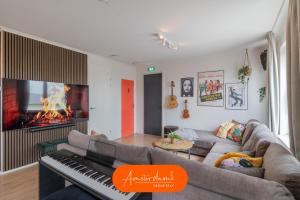 a living room with a couch and a piano at Amsterdam Group Villa 20 plus guests with Spa and Karaoke in Zwanenburg