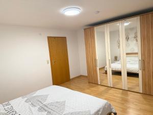 a bedroom with a bed and a large mirror at Wohnen am Rande des Schwarzwaldes in Eggingen