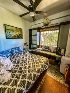 a bedroom with a bed and a ceiling fan at Casa Del Faro in Puerto Galera