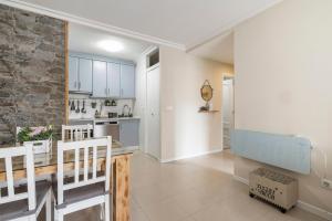 eine Küche und ein Wohnzimmer mit einer Steinwand in der Unterkunft Apartamento Morriña in Brion