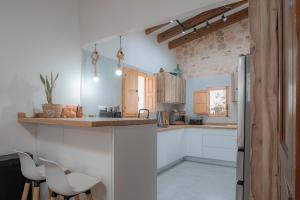 a kitchen with white cabinets and white appliances at Can Vicent Corda in Sant Francesc Xavier