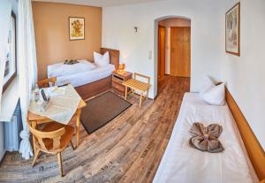 ein Hotelzimmer mit 2 Betten und einem Tisch in der Unterkunft Rammersweier Hof in Offenburg