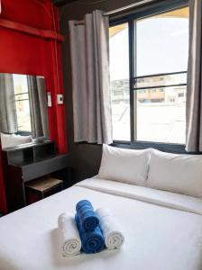 a bed with towels on it with a window at RoXx Social Hostel in Bangkok