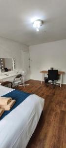 a bedroom with a bed and a desk and a desk at Spacious Double Room with Shared Bathroom in London