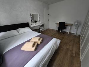 a bedroom with a bed with two towels on it at Spacious Double Room with Shared Bathroom in London +8 photos