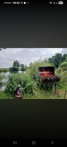 a boat sitting in the grass next to a river at Chez Bernard in Mareuil-Caubert