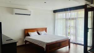 a bedroom with a bed and a large window at SB Guest in Trincomalee +7 photos