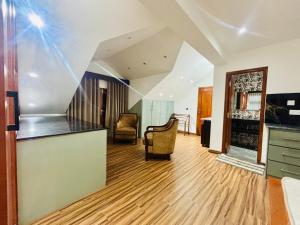 an empty living room with a staircase and chairs at SB Guest in Trincomalee