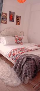 una camera da letto con due letti con lenzuola bianche di The Amber Homes a Meru