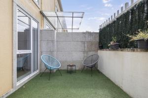 zwei Stühle und ein Tisch auf einer Terrasse in der Unterkunft Apartamento Morriña in Brion