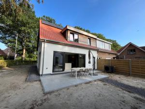 a house with a table and chairs in a yard at Villa Médard in Bruges