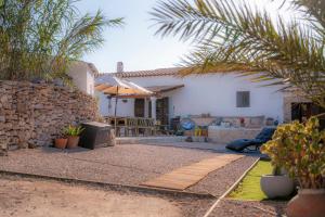 a house with a stone wall and a patio at Can Vicent Corda in Sant Francesc Xavier