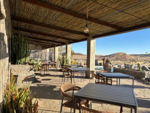 a patio with tables and chairs with a view of the desert at 3 ALOES GUESTHOUSE in Uis