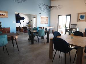 a dining room with wooden tables and blue chairs at 3 ALOES GUESTHOUSE in Uis