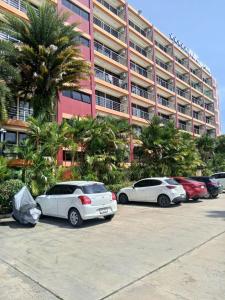 three cars parked in a parking lot in front of a building at Vacation by the ocean in Phuket