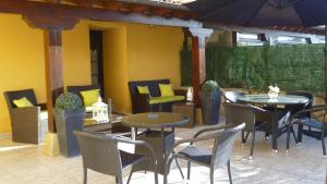 an outdoor patio with tables and chairs and an umbrella at Las Anjanas de Isla in Isla