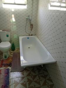 a bath tub in a bathroom with a toilet at Rest Hous Adis in Kyzart